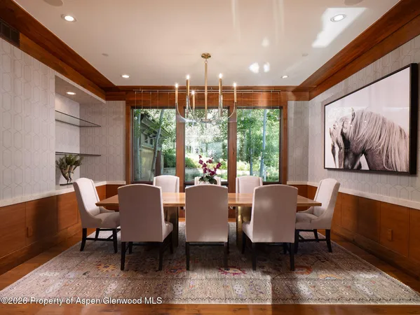 a dining room with furniture a rug and a chandelier