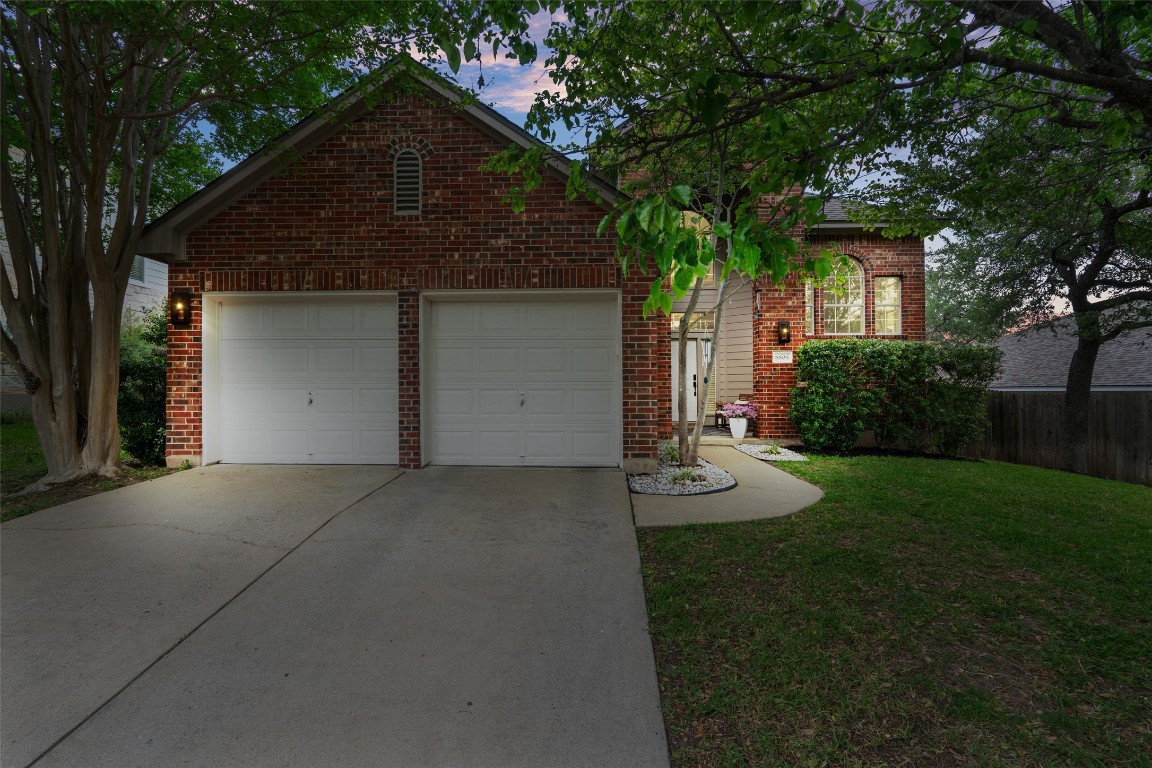 front view of house with a yard and trees