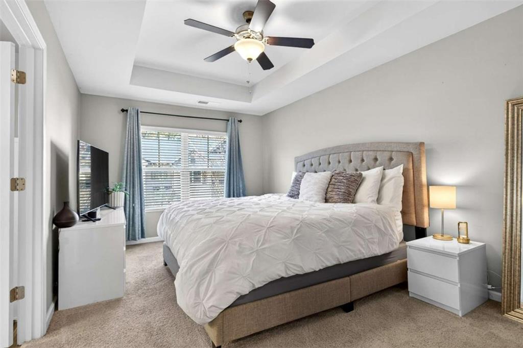 3182 Meadowstone Lane Southwest Atlanta, GA 30331 - Photo 17 of 32 a bedroom with a bed flat screen tv and a chandelier