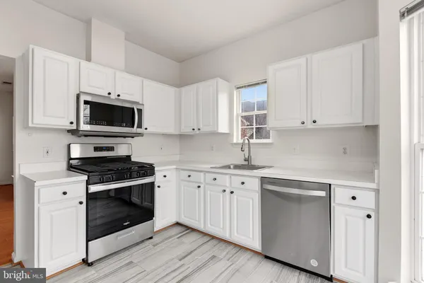 a kitchen with cabinets stainless steel appliances and a sink