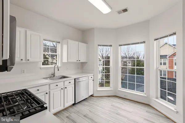 a kitchen with stainless steel appliances granite countertop a sink stove and cabinets