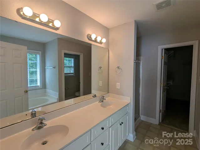 a bathroom with double vanity sink and a mirror