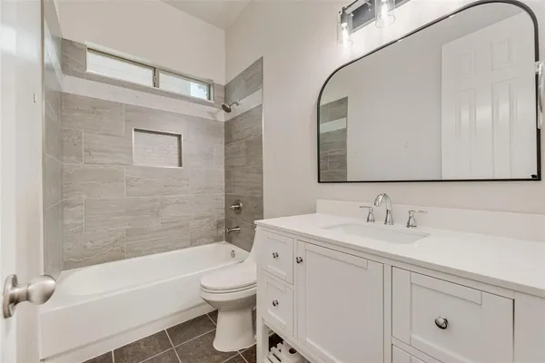 a bathroom with a toilet a sink a mirror a bathtub and shower