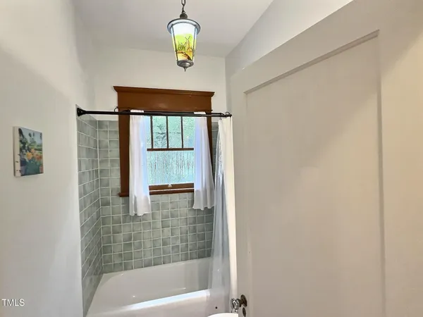 a view of a hallway with wooden floor and dining room