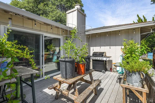 a view of a patio with table and chairs potted plants and floor to ceiling window