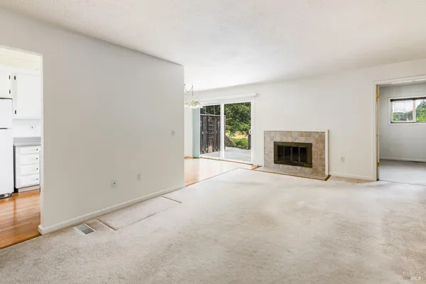 an empty room with floor to ceiling window and fireplace