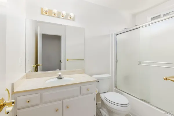 a bathroom with a sink a toilet a mirror and shower