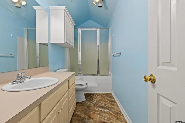 a bathroom with a sink toilet and shower