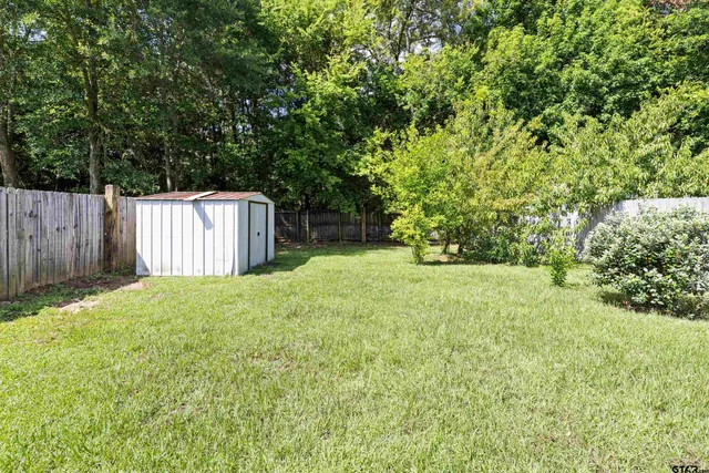 a view of a house with a large tree and a yard