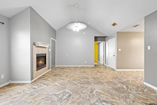 a view of an empty room with window and fire place
