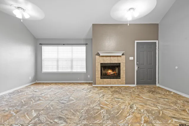 a view of an empty room with a fireplace and a window