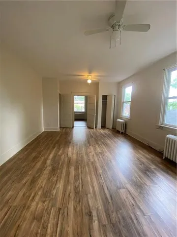 a view of a big room with wooden floor and windows