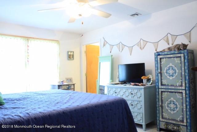 46 Cedar Run Road Bayville, NJ 08721 - Photo 15 of 16 a bedroom with a bed and a flat tv screen on the dresser
