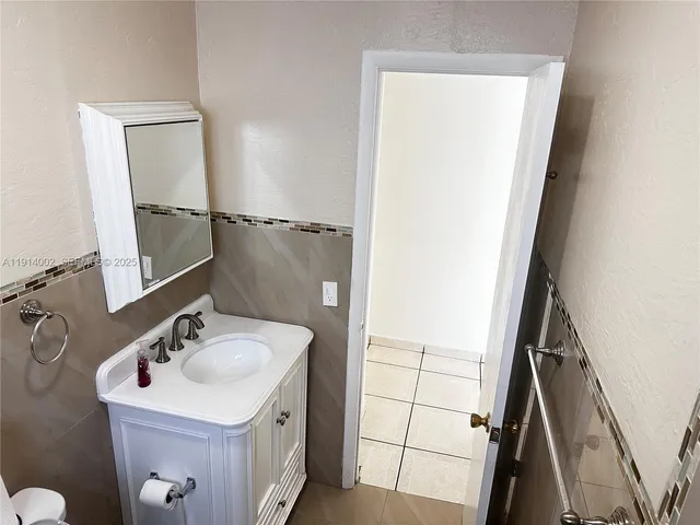 a bathroom with a granite countertop shower and a sink