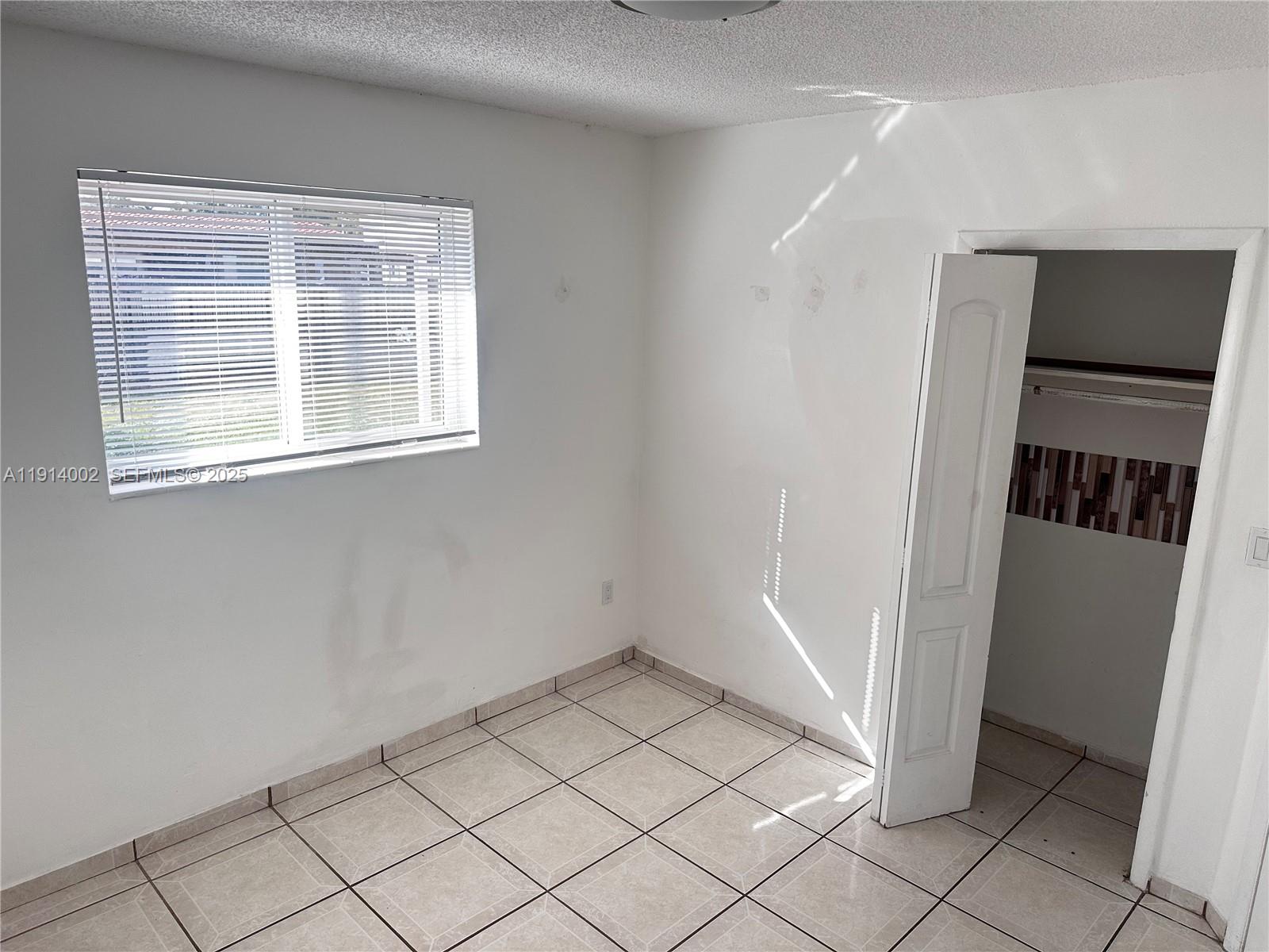 2914 Southwest 92nd Court Miami, FL 33165 - Photo 20 of 37 a view of an empty room with wooden floor and a window