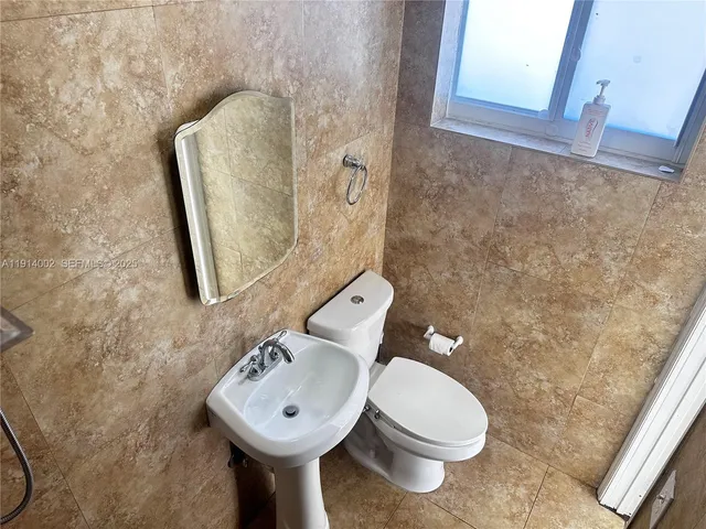 a white toilet sitting next to a bathroom sink