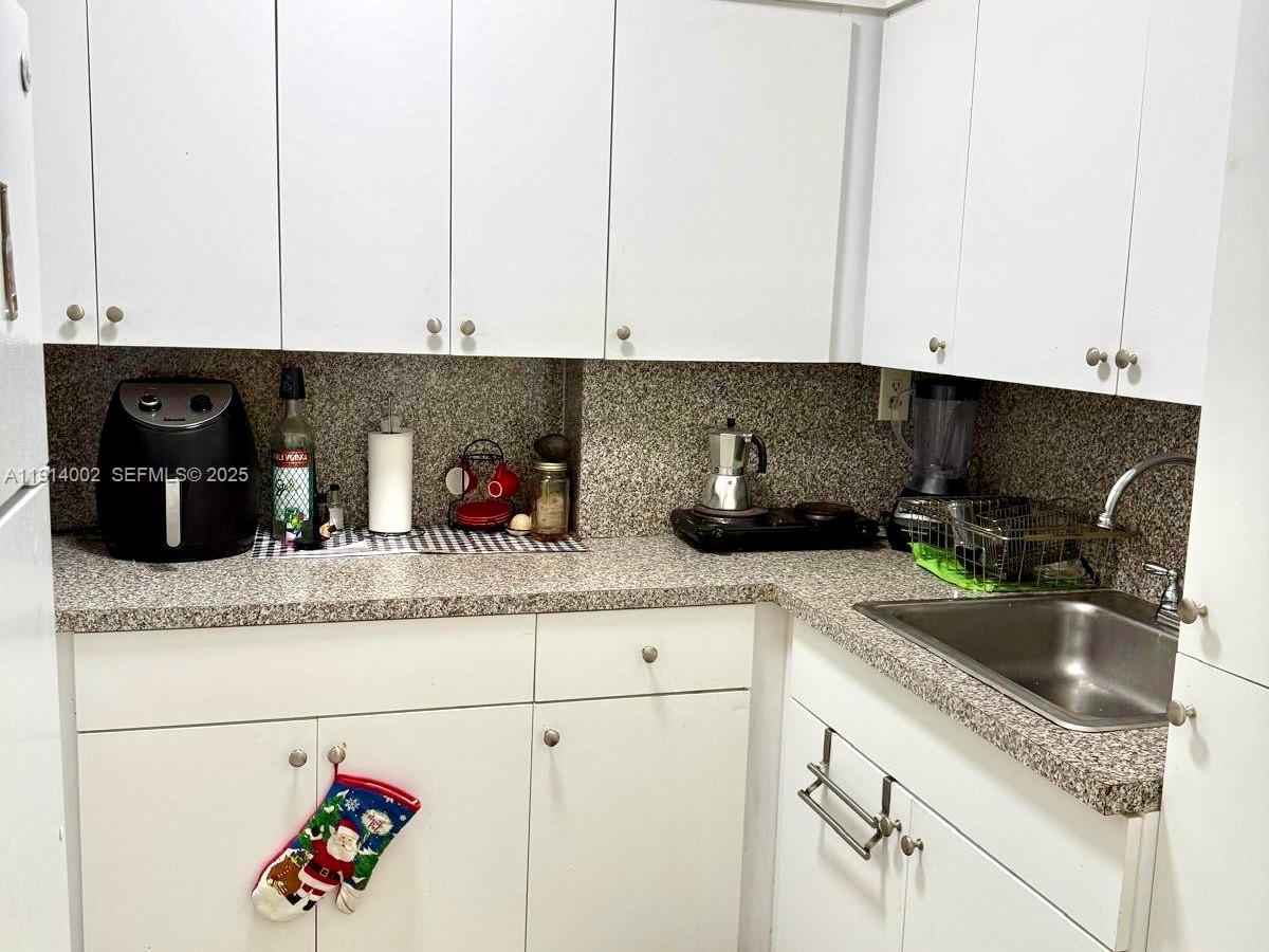 2914 Southwest 92nd Court Miami, FL 33165 - Photo 31 of 37 a kitchen with granite countertop a sink a stove and cabinets