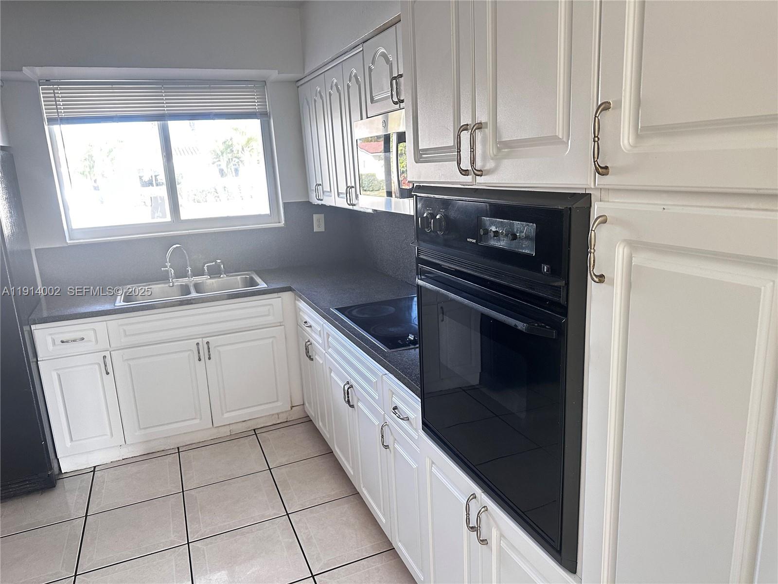 2914 Southwest 92nd Court Miami, FL 33165 - Photo 8 of 37 a kitchen with granite countertop white cabinets and white appliances
