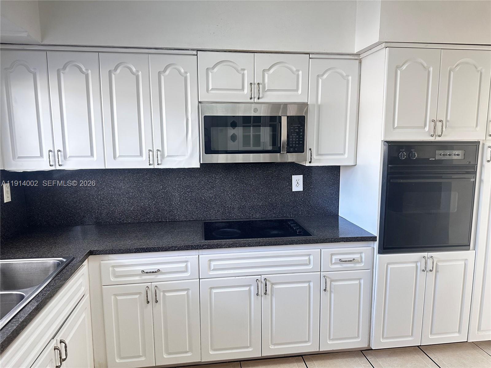 2914 Southwest 92nd Court Miami, FL 33165 - Photo 10 of 39 a kitchen with white cabinets and black appliances
