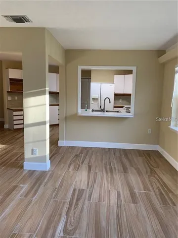 a view of a kitchen with wooden floor and electronic appliances
