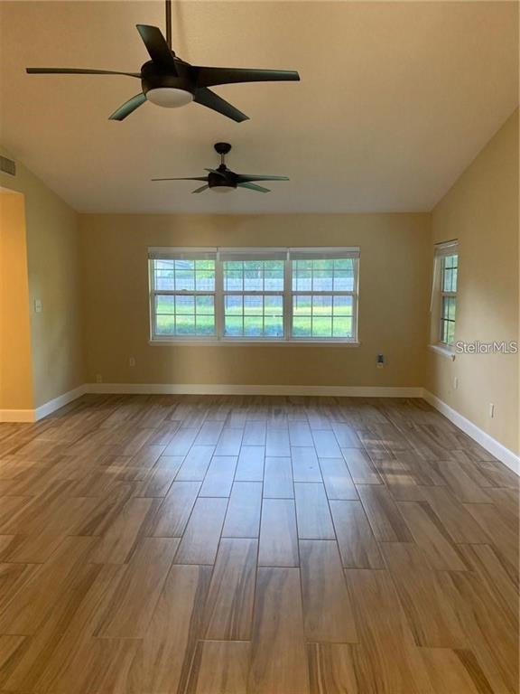 3090 Sunset Point Road Clearwater, FL 33759 - Photo 5 of 16 an empty room with wooden floor and windows