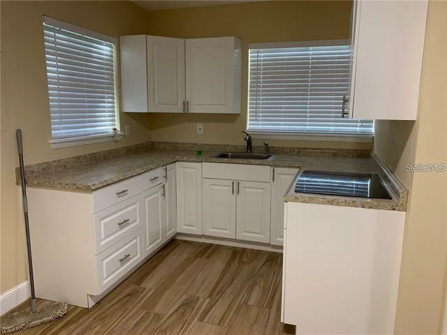a kitchen with granite countertop white cabinets and white appliances