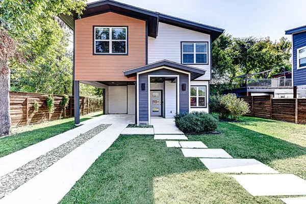 a front view of a house with yard and green space