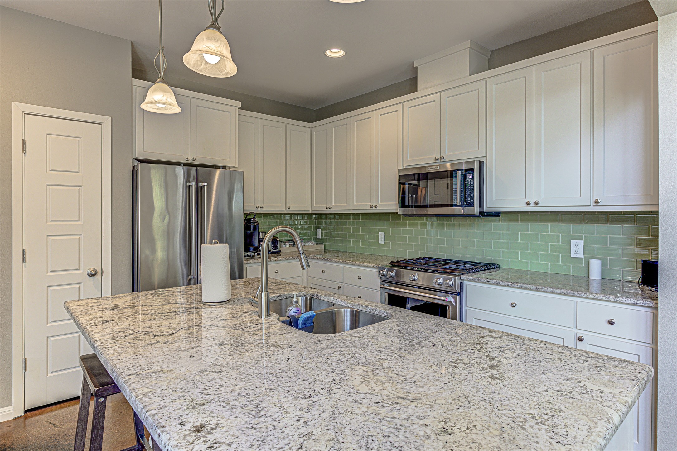 4809 Bolm Road Austin, TX 78702 - Photo 13 of 29 a kitchen with granite countertop a refrigerator and a stove top oven