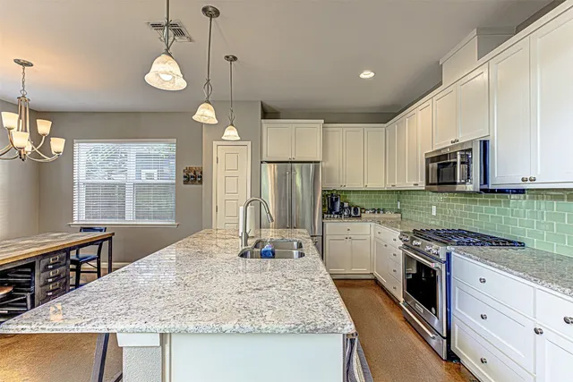 a kitchen with kitchen island granite countertop a sink appliances cabinets and counter space