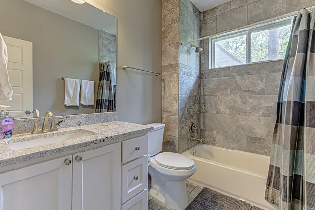 a bathroom with a granite countertop sink toilet and shower