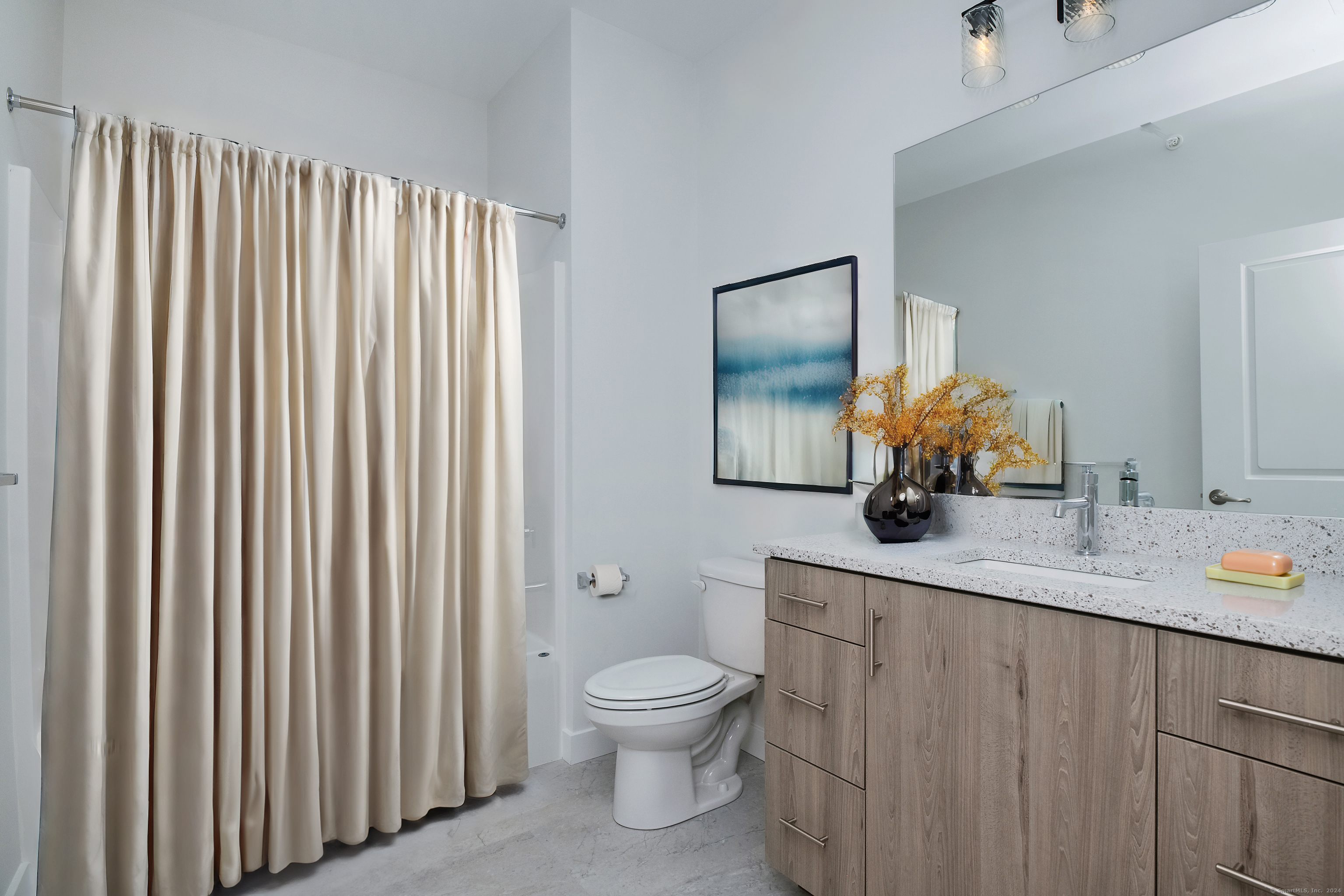 100 North Main Street, Unit 303 Bristol, CT 06010 - Photo 7 of 10 a bathroom with a granite countertop sink toilet and mirror
