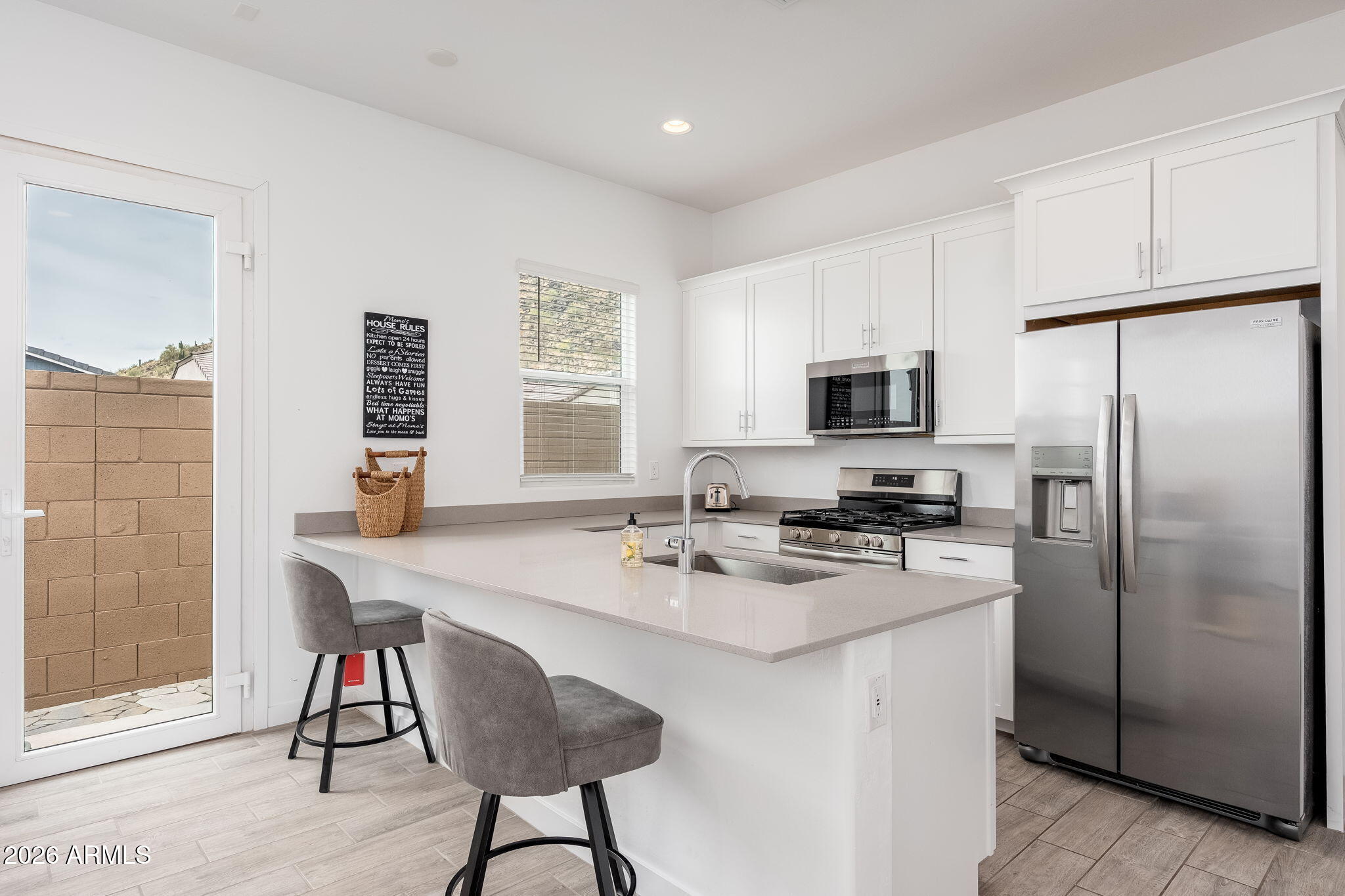 3272 West Peak View Road Phoenix, AZ 85083 - Photo 25 of 47 a kitchen with stainless steel appliances granite countertop a stove a refrigerator a microwave a sink and white cabinets