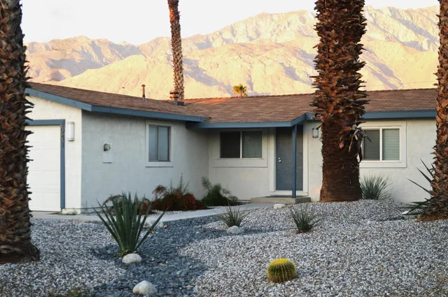 a view of a house with backyard and sitting area