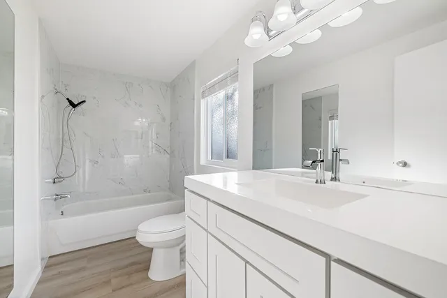 a bathroom with a sink a toilet and a large mirror