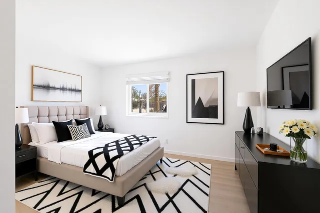 a bedroom with a bed and wooden floor