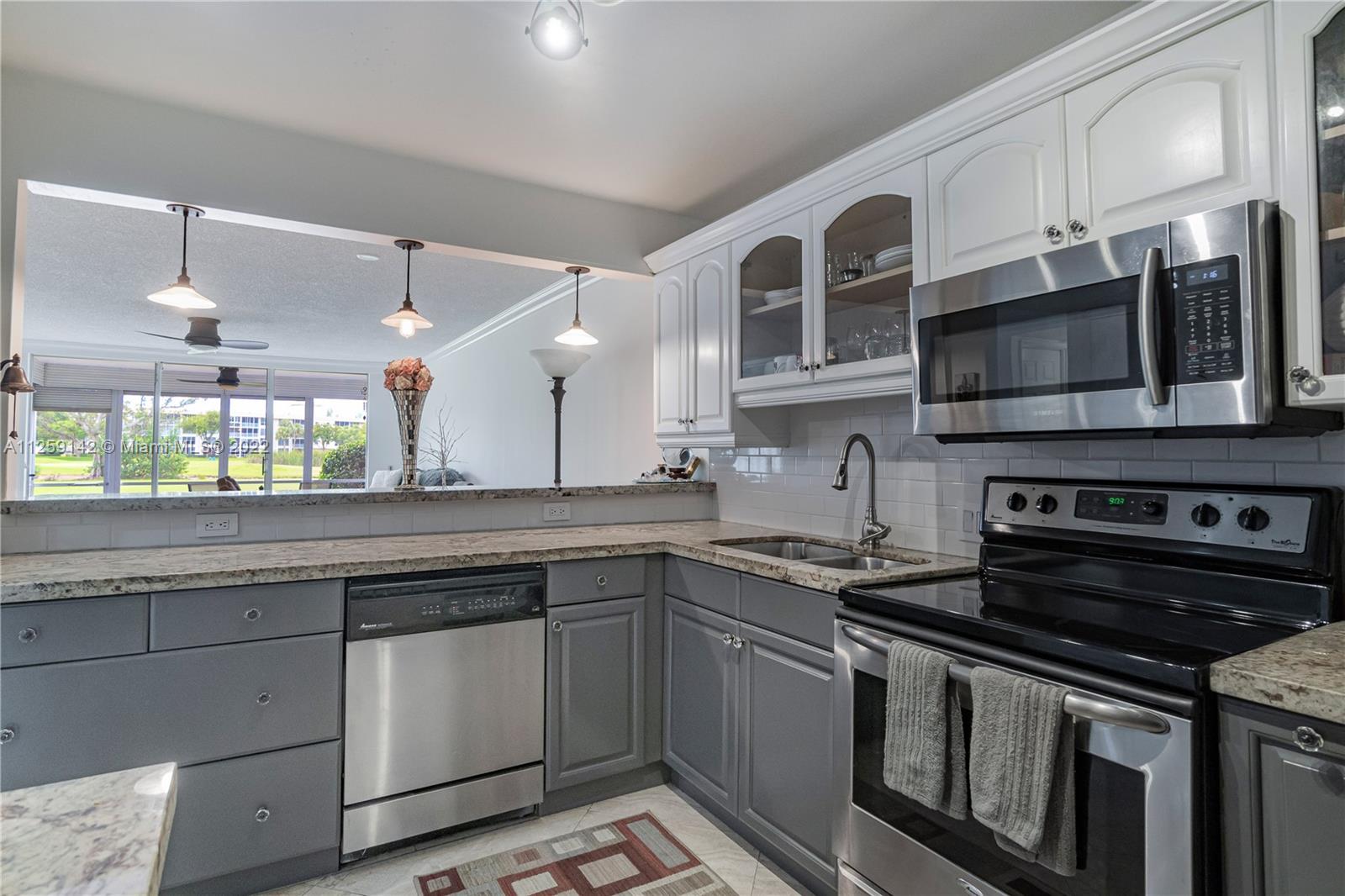 a kitchen with stainless steel appliances granite countertop a stove and a microwave