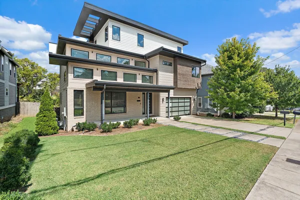 front view of a brick house with a yard