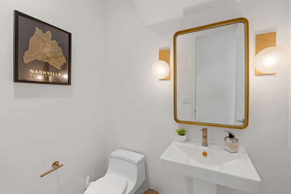 a bathroom with a toilet sink and mirror