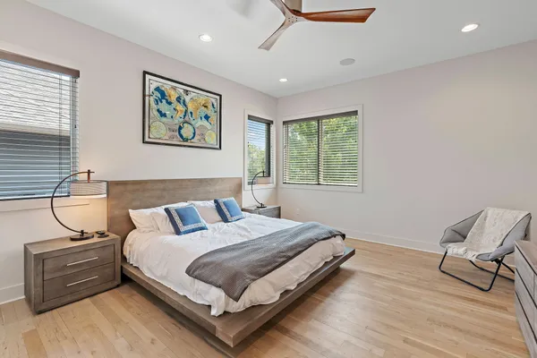 a bedroom with a bed a dresser and chair