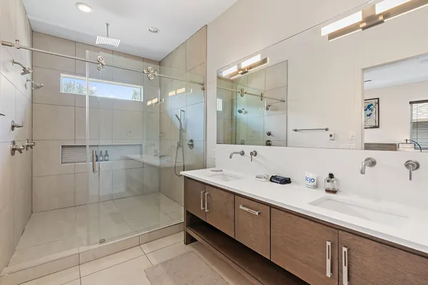 a spacious bathroom with a double vanity sink mirror and shower