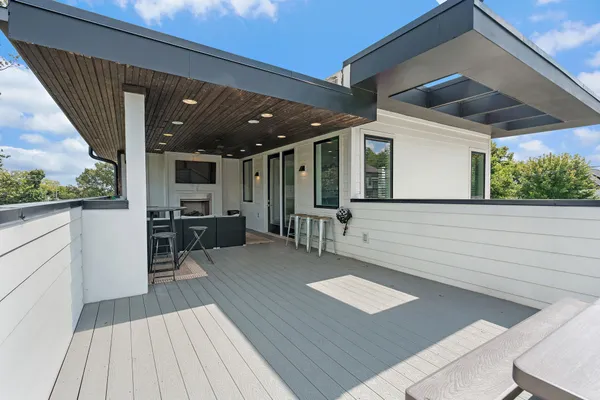 a view of a patio with table and chairs with wooden floor and fence