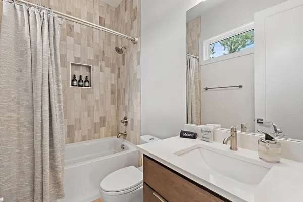 a bathroom with a sink a toilet a mirror and shower