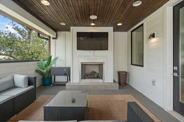 a living room with furniture a flat screen tv and a fireplace