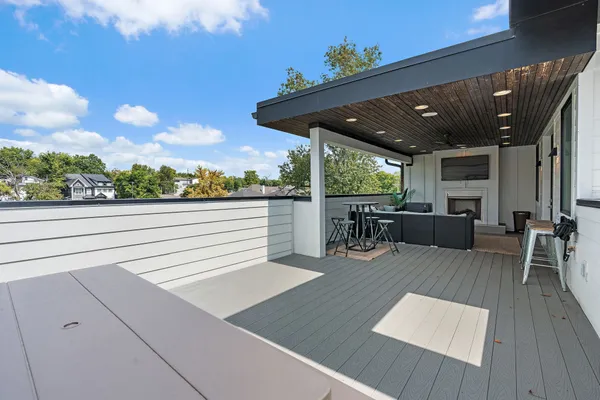 a view of a patio with table and chairs with wooden floor and fence