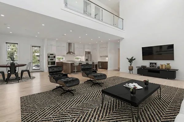 a living room with furniture a flat screen tv and kitchen view