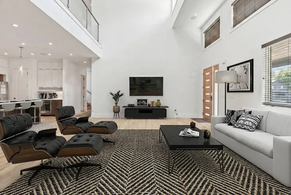 a living room with furniture a rug and a flat screen tv