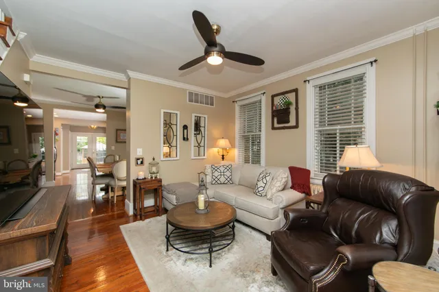 a living room with furniture wooden floor and a large window