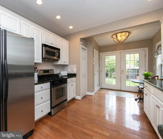 a kitchen with a refrigerator a stove top oven a sink and a window