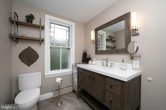 a bathroom with a toilet sink and mirror