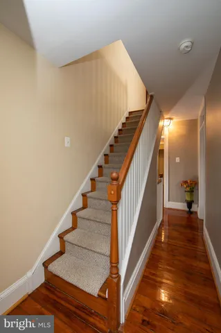 a view of staircase with lots of frames on wall and wooden floor